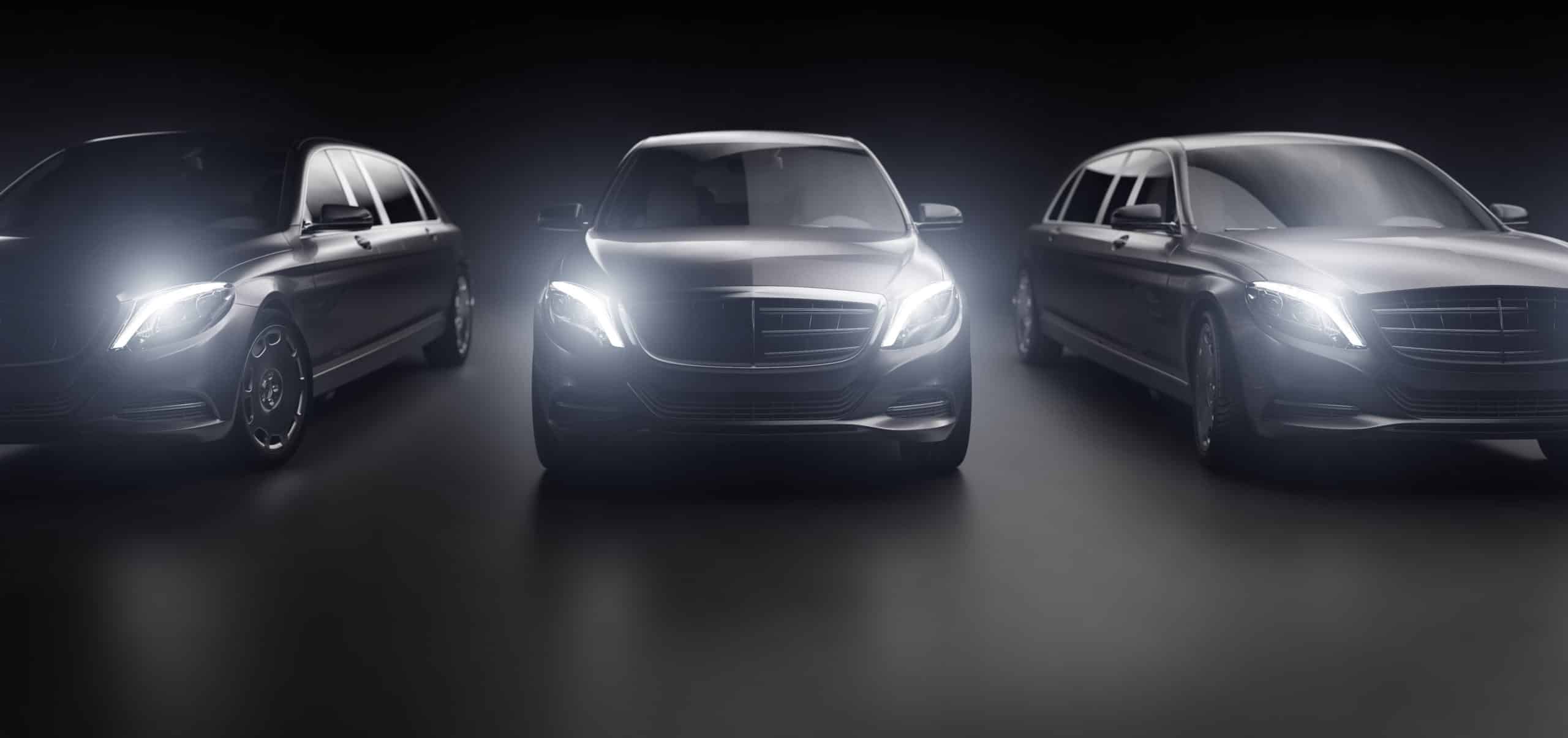 Luxurious cars, limousines in garage with lights turned on. Generic and brandless yet contemporary and elegant look. 3D illustration